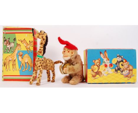 Two vintage Max Carl original West Germany made clockwork animals to include; monkey playing the cymbals &amp; giraffe with m