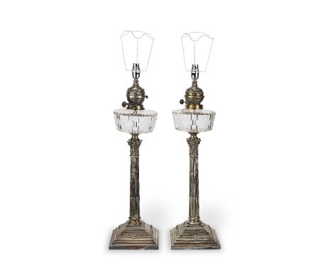 A pair of late 19th century silver-plated oil lamp basesWith brass burners above cut-glass reservoirs on stop-fluted Corinthi