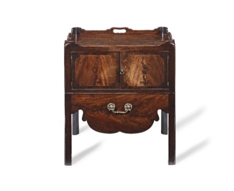 A George III mahogany bedside commode Second half 18th century The shaped tray top with three pierced fret handles above a pa