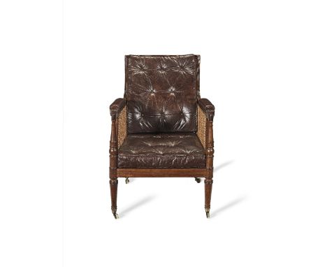 A Regency mahogany library bergère The curved back, arms and seat with caned panelling, together with button-upholstered back