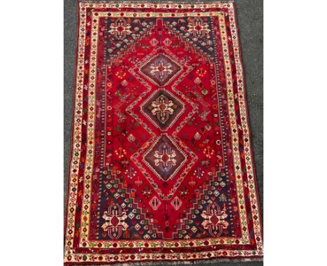 A South West Persian Qashga’i rug / carpet, knotted with traditional stylised figures and abstract motifs, in rich tones of r