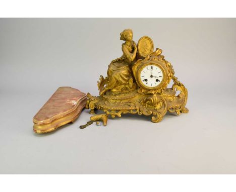 A late 19th French gilt spelter, Rococo style, mantel clock, with a 3" enamelled dial flanked by a seated lady holding a pict