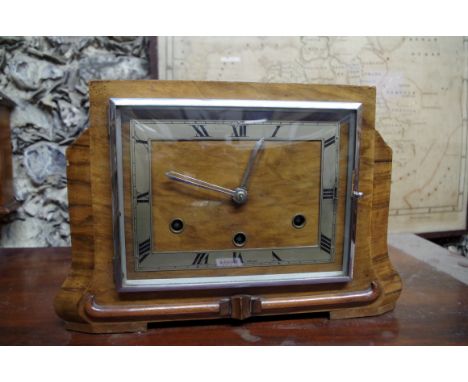 An Art Deco walnut mantel clock, striking on four straight gongs, 33cm wide.&nbsp; 