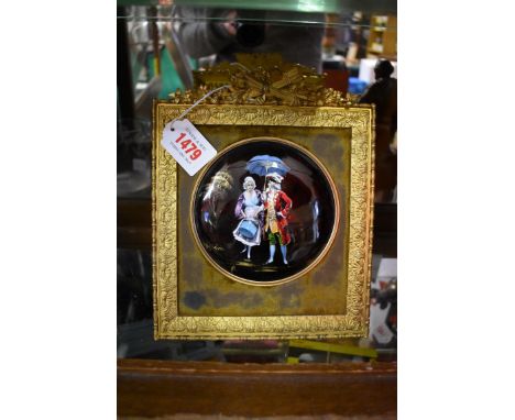 A Limoges enamel plaque painted with two Georgian figures, monogrammed, 12cm diameter, in an cast gilt brass easel back frame