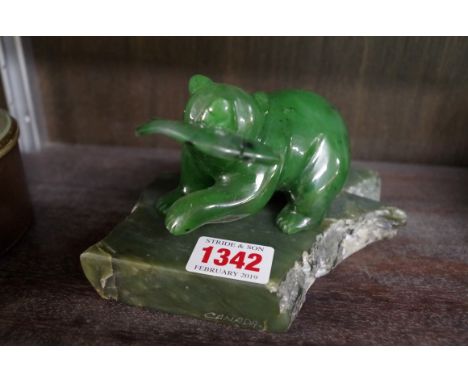 An Inuit carved green jade figure group of a bear and salmon, inscribed to underside of foot, on conforming stand, inscribed 