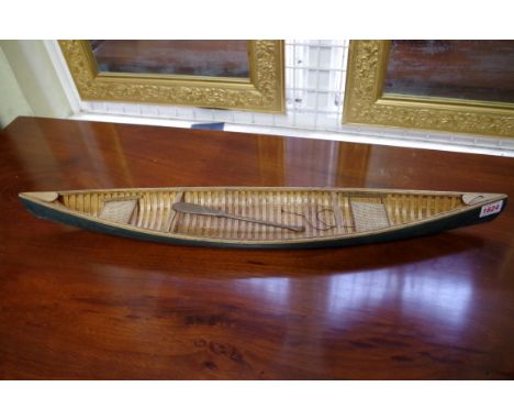 A scratch built model of a canoe,&nbsp;with carvel planking, 70cm long, with small paddle.&nbsp; 