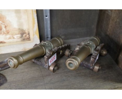 A pair of antique brass model cannons,&nbsp;on oak carriages, the cannons 19.5cm long.&nbsp;&nbsp; 