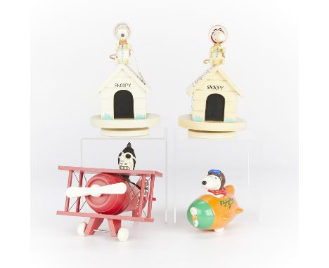 Group of four wooden toys relating to Snoopy as the Flying Ace and an astronaut including:Two music boxes depicting Snoopy as