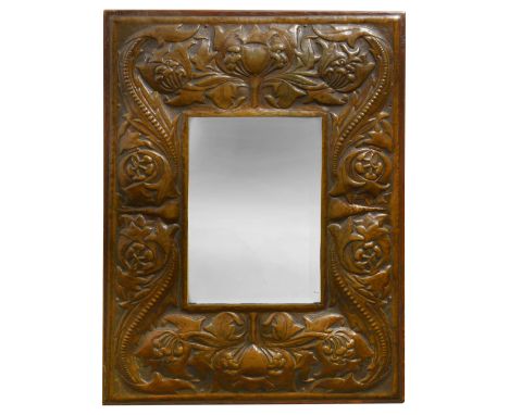An early 20th century Arts &amp; Crafts repousse embossed copper and oak wall mirrorrectangular bevelled plate, the surround 