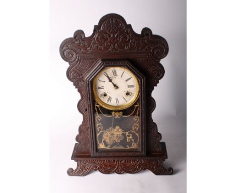 An American shelf clock by the Waterbury Clock Company with gilt decorated glazed door, 22" high