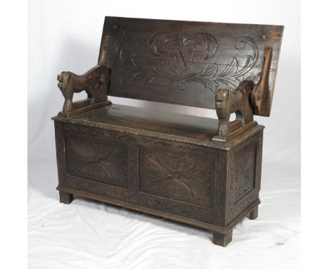 A monk's carved oak bench with box seat, on turned supports, 42" wide