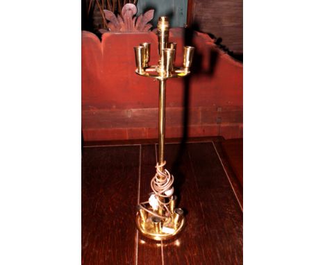 A circular brass ten-light candle holder in the style of Christopher Dresser, fitted as a table lamp, and an Art Deco ebony a