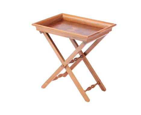 David Linley; an English walnut folding tray topped low tea table with central quartered burr panel within an everted rim, th