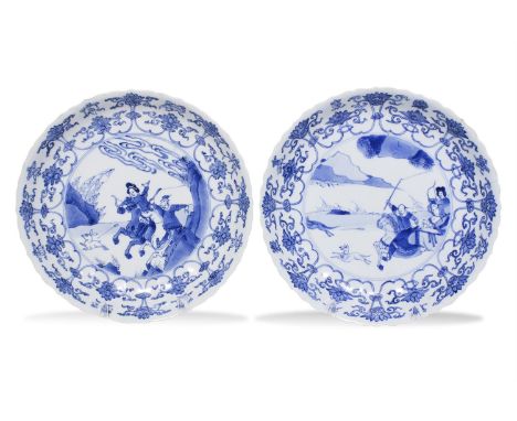 A PAIR OF CHINESE BLUE AND WHITE 'HUNTING' DISHES, Kangxi period (1662-1722)each of shallow circular form, with barbed rim, t