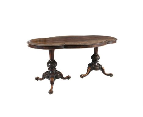 A VICTORIAN SHAPED ROSEWOOD CENTRE TABLE, with moulded rim, on twin facetted and bulbous carved supports, on lobed platform b