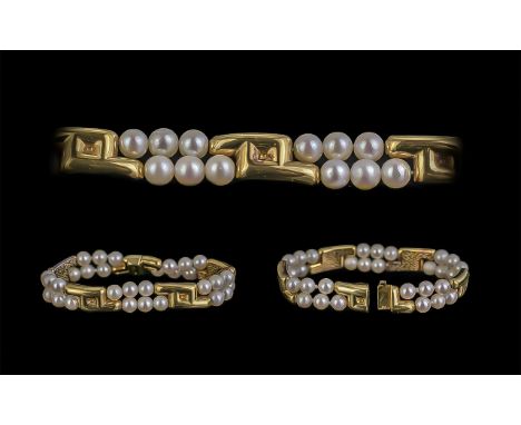 A Superb Quality Ladies Signed 18ct And Cultured Pearl Set Bracelet Of Cotemporary Design. Marked 750-18ct and signed JKA for