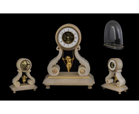 Cream Marble Clock, square base with shaped supports, with a cherub on a swing between.  White face, Roman numerals. Raised o