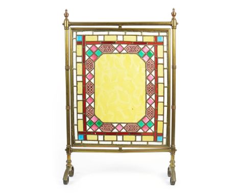 An Aesthetic Movement brass and coloured glass firescreen, the central rectangular panel with moulded amber glass vase with l