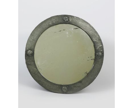 A Pewter wall mirror, possibly retailed by Liberty &amp; Co, circular cast in relief with foliate roundels, unsigned, 56cm. d