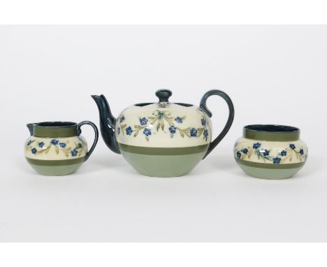 A James Macintyre  &amp; Co tea set probably designed by William Moorcroft, tubeline decorated with swags of blue flowers, in