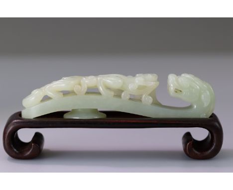 the almost white stone with soft polish, finely carved in openwork with a sinuous chilong, biting on a spray of lingzhi fungu