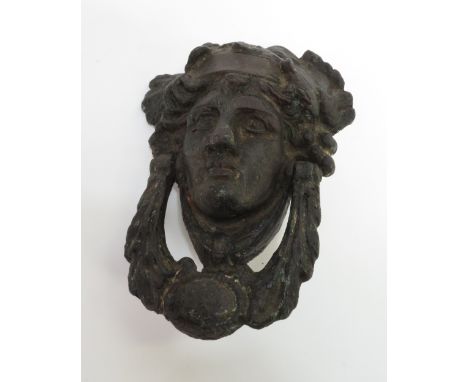A cast iron door knocker in the form of a male head
