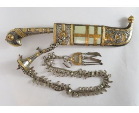 A 19th century middle eastern dagger/knife with embossed silvered decoration, the grip in the form of a birds head, set with 