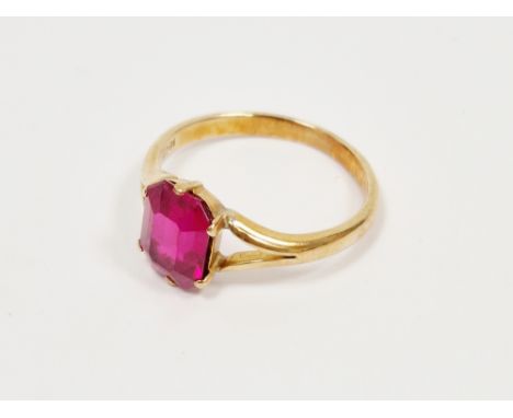 18ct yellow gold and ruby dress ring, the claw set emerald cut ruby approximately 10mm high, held on a split shoulder plain r
