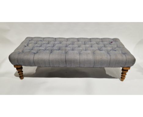 Modern ottoman stool, the top upholstered in a buttoned blue chevron fabric, on turned wooden legs, 39cm high x 148cm long x 