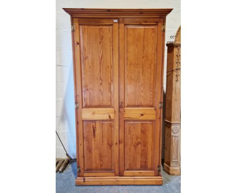 Modern pine wardrobe, the two panel doors opening to a shelf and a hanging rail, on plinth base (with key), 190cm high x 106c