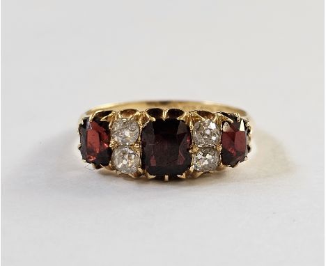 18ct gold, garnet and diamond ring, the three graduated mix cut garnets interspersed by two pairs of old cut diamonds, finger