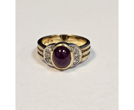 18ct yellow gold, ruby and diamond dress ring, the oval cabochon ruby flanked either side by three pave set small diamonds, s