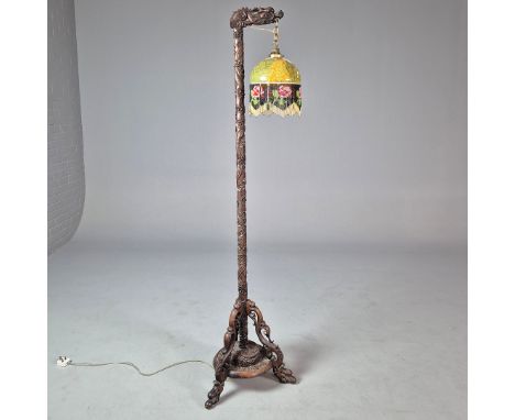 A 19TH CENTURY CHINESE CARVED FLOOR LAMP. Padoukwood, ornately carved with a coiled dragon with a marbled glass and beaded sh