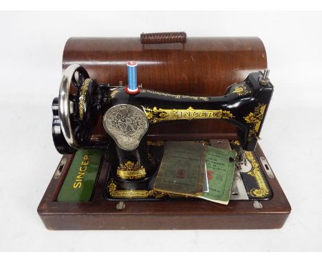 A vintage Singer sewing machine in wooden carry case.