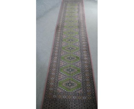 A green ground Bokhara motif runner. L.350 W.70cm 