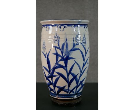 A large Oriental blue and white ceramic stylised floral design vase. H.36 Diam.21cm (inc. stand) 