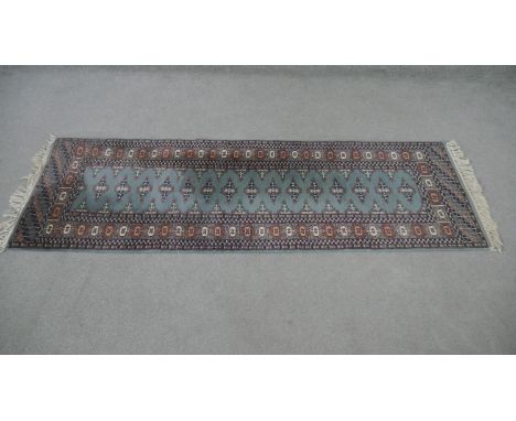 A Pakistan Bokhara runner blue ground hand made. L.186 W.62cm. 
