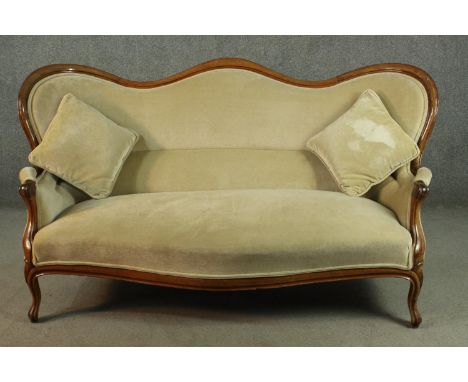 A Victorian walnut framed hump back sofa, upholstered in green velour, on cabriole legs.  H.96 W.185 D.58cm. 