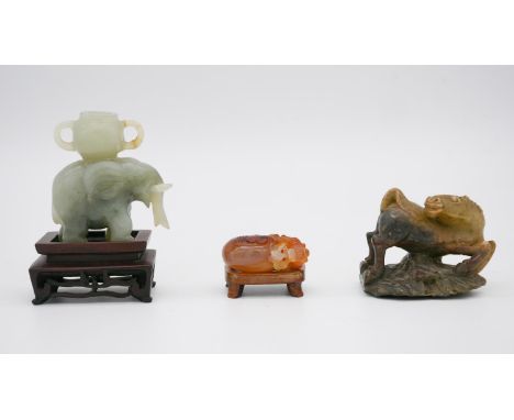 Three Chinese carved stone pieces, including a Jade elephant on carved stand (handle of basket broken), a carnelian carved go