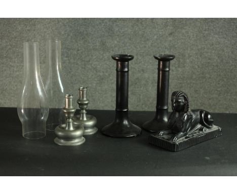 A pair of pewter candle sticks, a pair of black ceramic candle sticks, two funnels and a depression glass black sphinx paperw