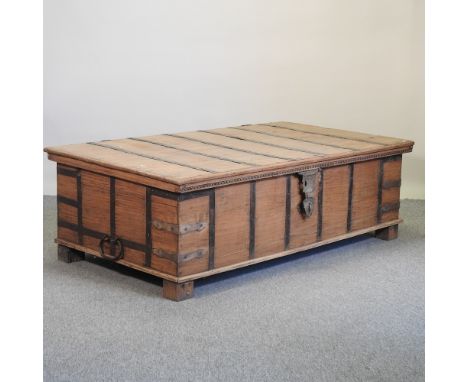 A large early 20th century Indian hardwood trunk/coffee table, with a hinged lid, 174cm