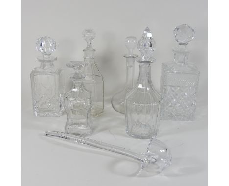 A collection of six glass decanters and stoppers, together with a glass ladle