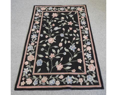 A tapestry of coloured flowers, on a black ground, 176 x 116cm