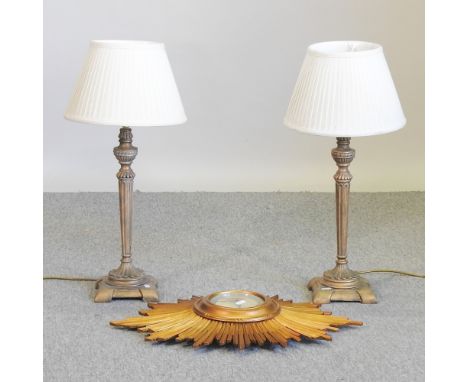 A sunburst wall clock, 60cm, together with a pair of gold painted table lamps and shades