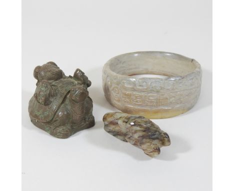 A hardstone netsuke of a recumbent horse, looking back over its shoulder, 6cm, together with a carved Egyptian bangle and an 