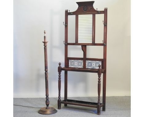 An Edwardian tile back hall stand, inset with a mirror, 84cm, together with a carved wooden standard lamp (2)