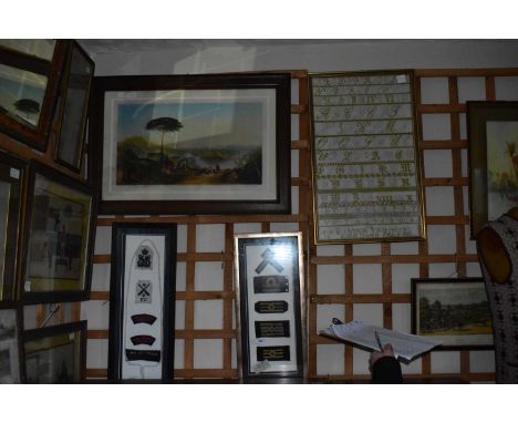 A collection of decorative prints including military arm badges, alphabet sampler, various prints, ceramic/shell picture etc.