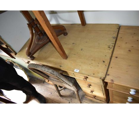 An old pine flat top kneehole desk with an arrangement of nine drawers, on plinth base, width 107cm, depth 61cm, height 76cm.