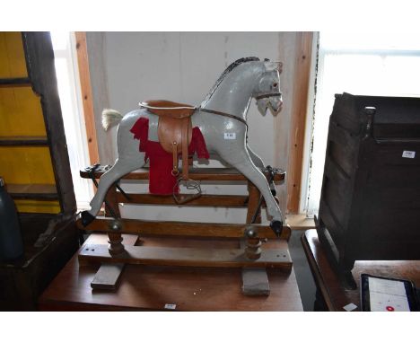 A vintage painted rocking horse, height 84cm.Condition Report: General wear throughout, losses and chips to the paint, cracks