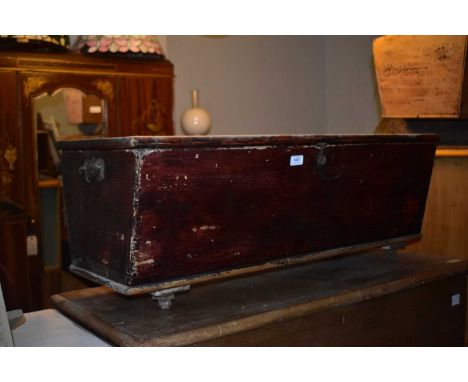 An old stained pine dough trough with drop handles, on castors, length 98cm.